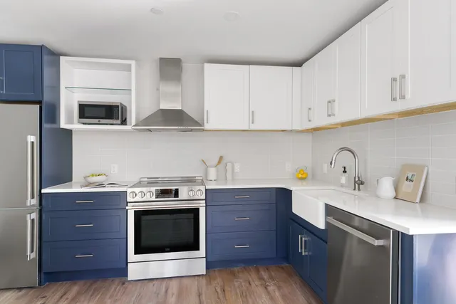 a kitchen with stainless steel appliances granite countertop a stove a sink and a microwave