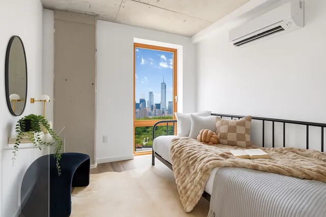 a bedroom with a large bed and a potted plant