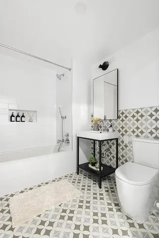 a bathroom with a sink toilet a mirror and shower