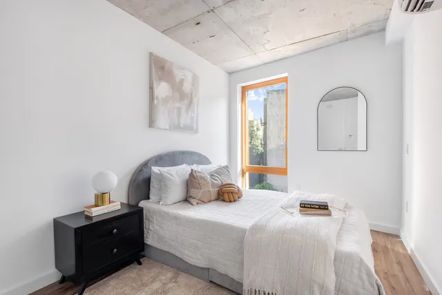 a bedroom with a bed and wooden floor