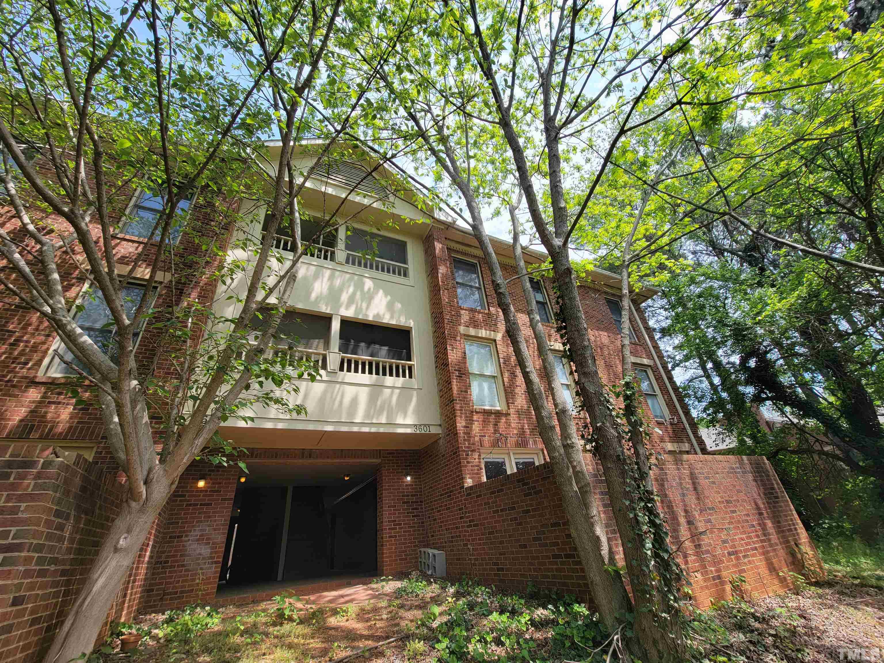 a front view of a house with a tree