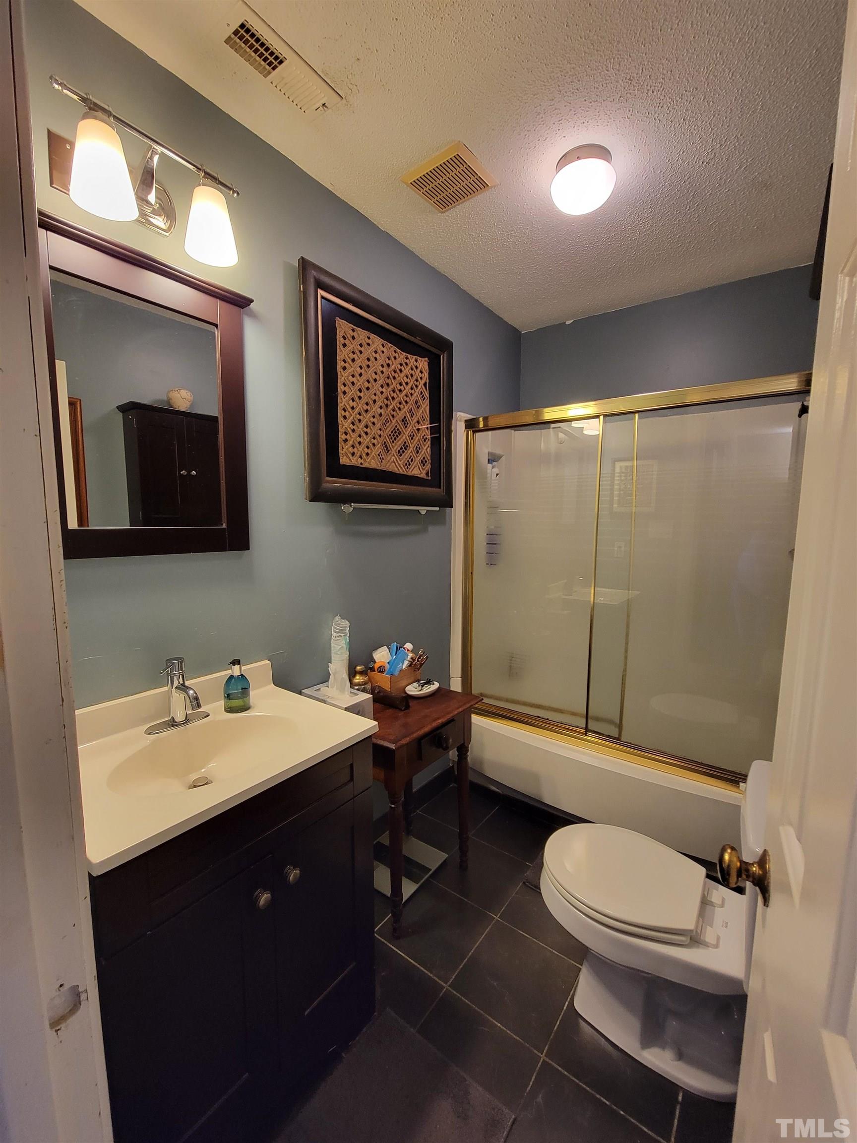 3601 Helix Court, Unit 302 Raleigh, NC 27606 - Photo 13 of 21 a bathroom with a toilet a sink and mirror