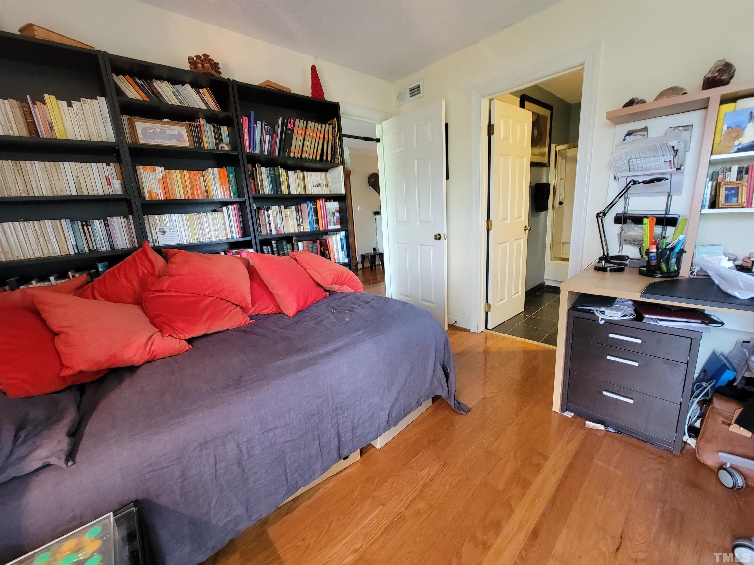 3601 Helix Court, Unit 302 Raleigh, NC 27606 - Photo 16 of 21 a bedroom with a bed and a book shelf