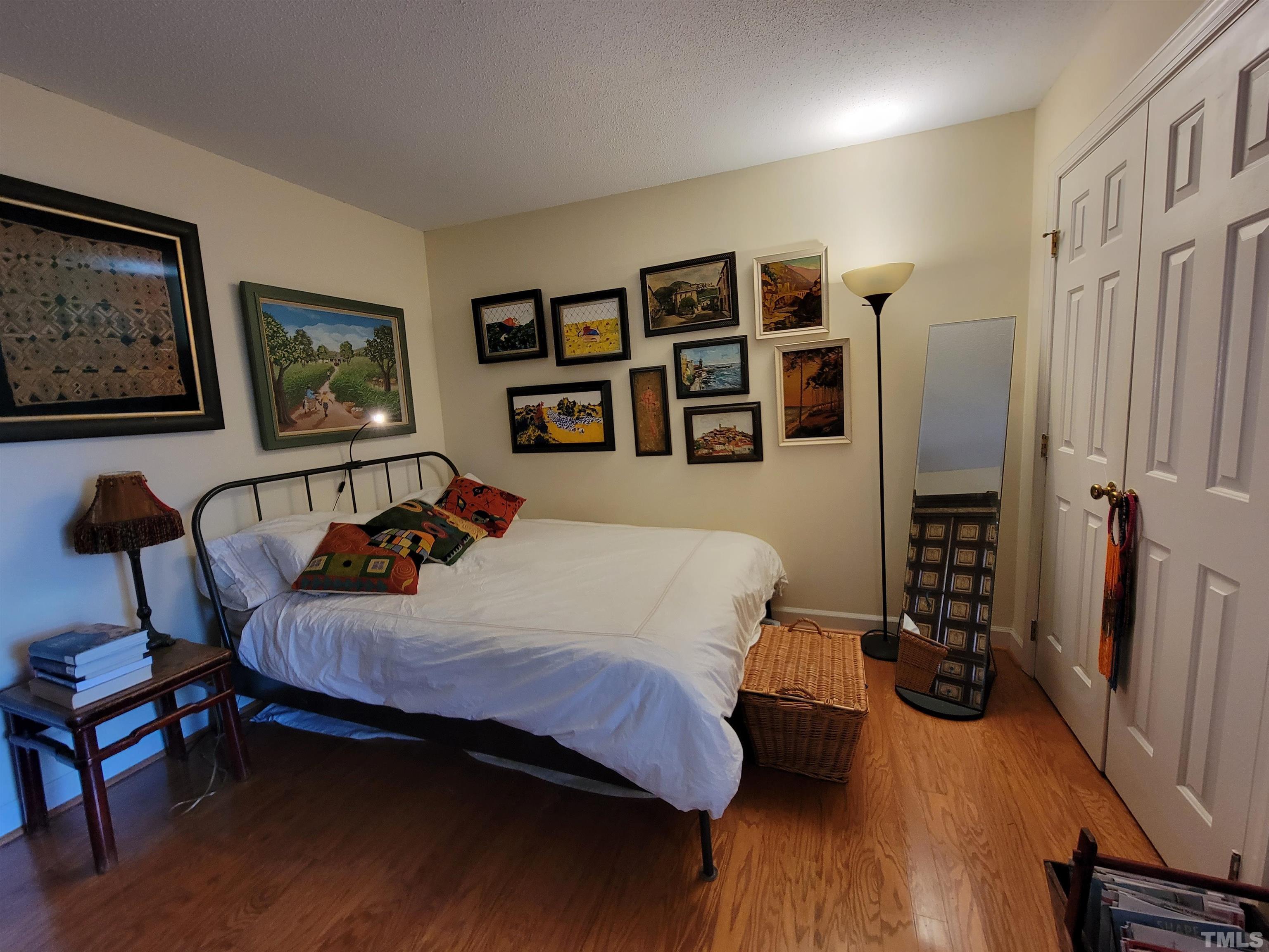3601 Helix Court, Unit 302 Raleigh, NC 27606 - Photo 10 of 21 a bedroom with a bed a dresser and book shelf