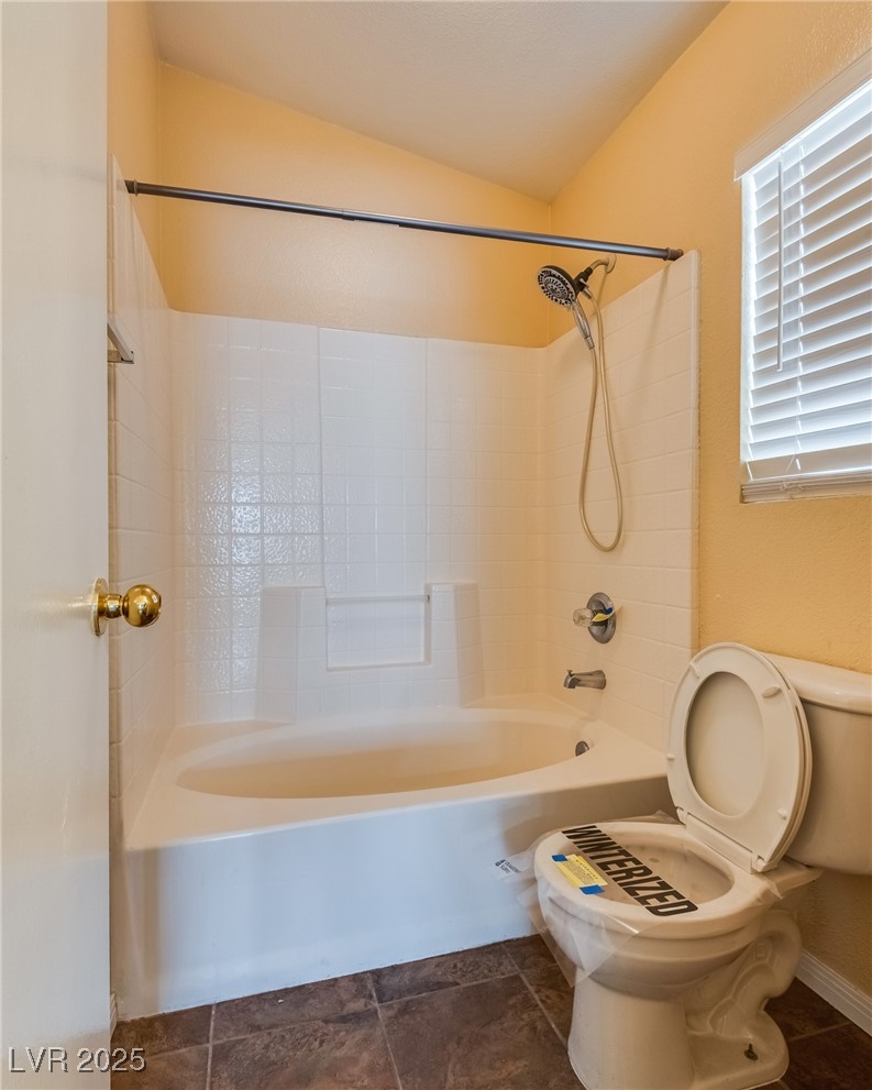 6354 Rusticated Stone Avenue, Unit 101 Henderson, NV 89011 - Photo 13 of 21 Full bathroom with washtub / shower combination and dark tile patterned floors