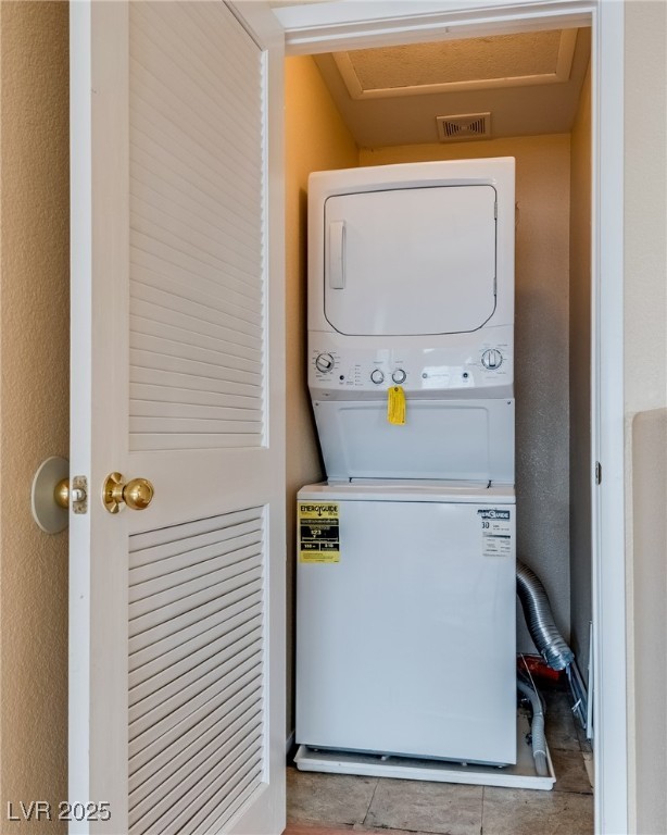 6354 Rusticated Stone Avenue, Unit 101 Henderson, NV 89011 - Photo 15 of 21 Laundry room featuring stacked washer and clothes dryer and light tile patterned flooring