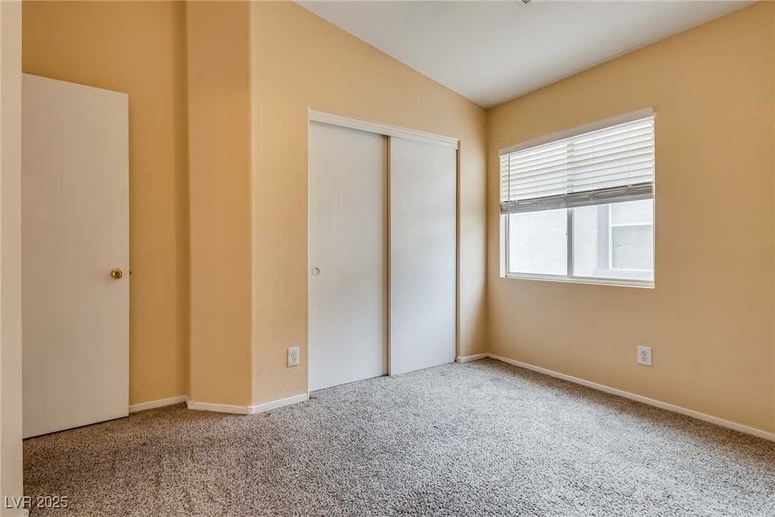 6354 Rusticated Stone Avenue, Unit 101 Henderson, NV 89011 - Photo 18 of 21 Unfurnished bedroom with carpet flooring and a closet