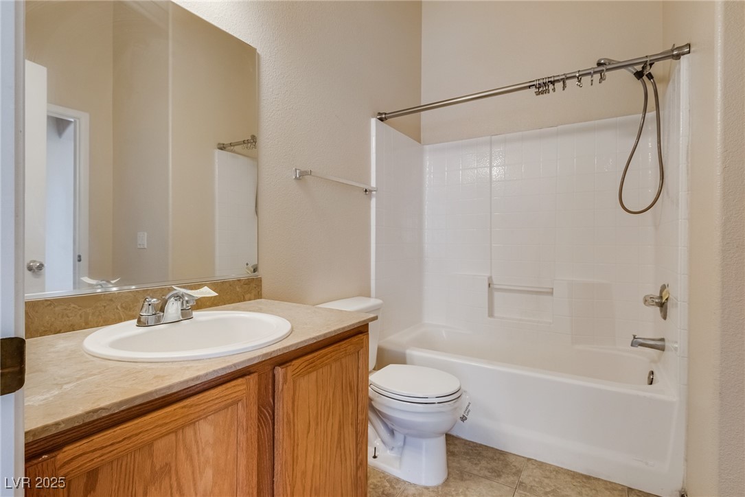 6354 Rusticated Stone Avenue, Unit 101 Henderson, NV 89011 - Photo 19 of 21 Bathroom featuring vanity, shower / tub combination, and light tile patterned floors