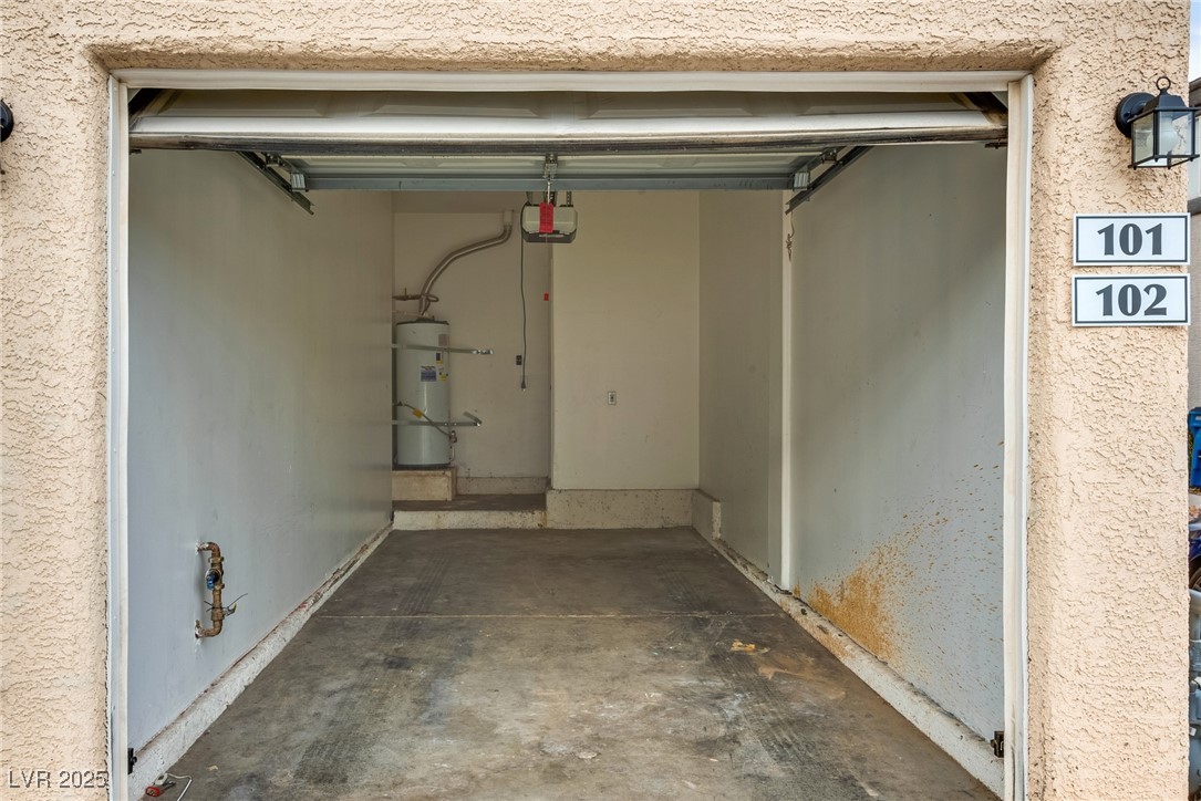 6354 Rusticated Stone Avenue, Unit 101 Henderson, NV 89011 - Photo 2 of 21 Garage featuring water heater and a garage door opener