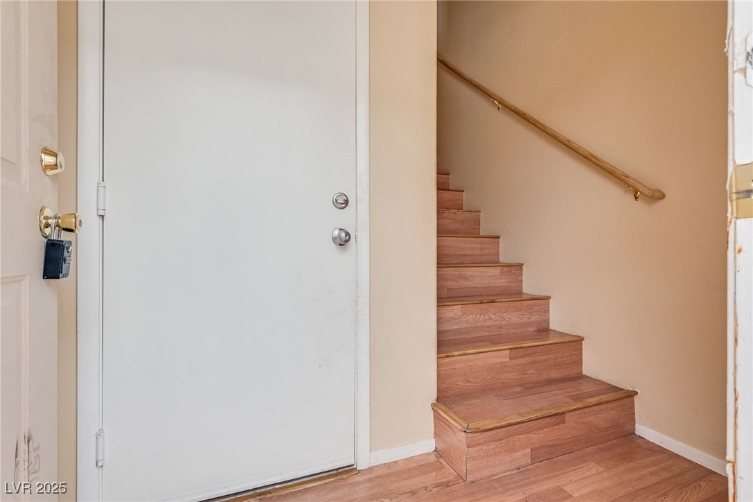 6354 Rusticated Stone Avenue, Unit 101 Henderson, NV 89011 - Photo 3 of 21 Stairs featuring wood finished floors and baseboards