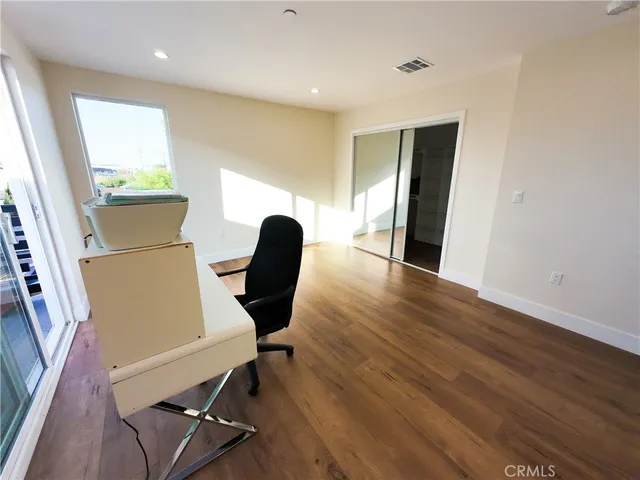 a view of a workspace with furniture and a window