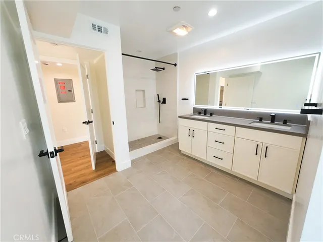 a spacious bathroom with a granite countertop sink mirror and a