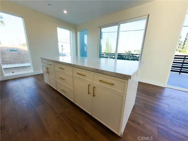 a hallway with wooden floors and cabinet
