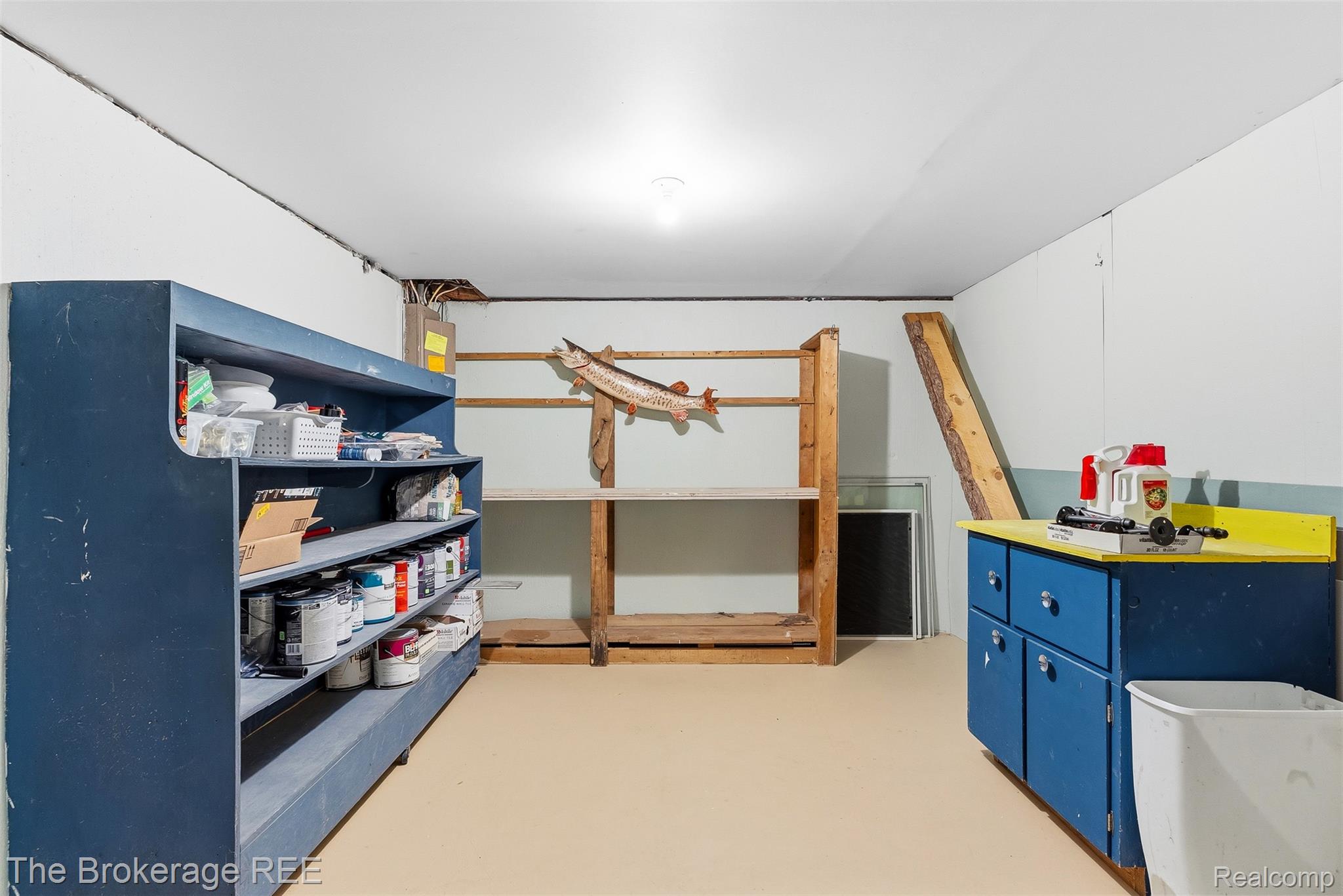 6509 Silver Lake Road Linden, MI 48451 - Photo 34 of 43 Versatile lower-level space featuring built-in shelving, a dedicated workbench area, ample storage solutions, and a neutral flooring finish