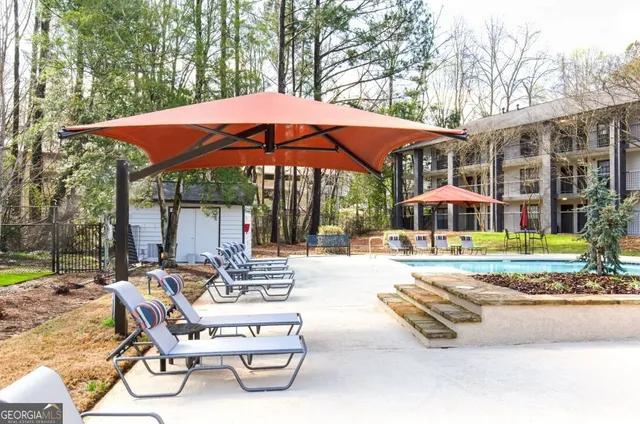 a view of a house with backyard and sitting area
