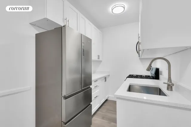 a kitchen with a refrigerator sink and cabinets