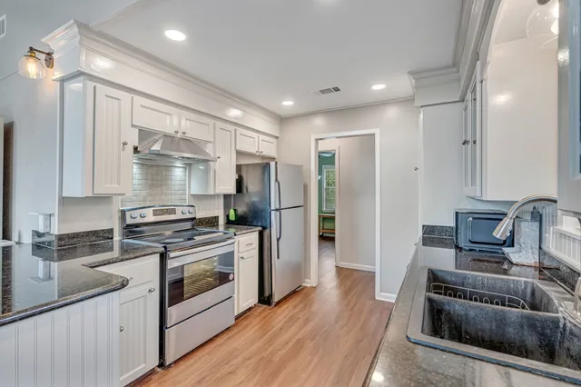 a kitchen with kitchen island stainless steel appliances a sink stove and refrigerator