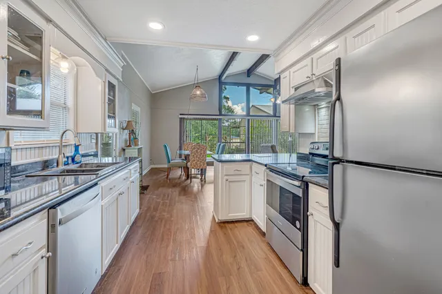 a kitchen with stainless steel appliances granite countertop hardwood floor sink stove and wooden floor