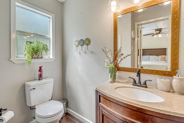 a bathroom with a granite countertop sink a toilet and a mirror