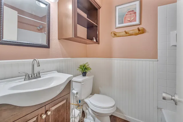 a bathroom with a toilet sink and mirror