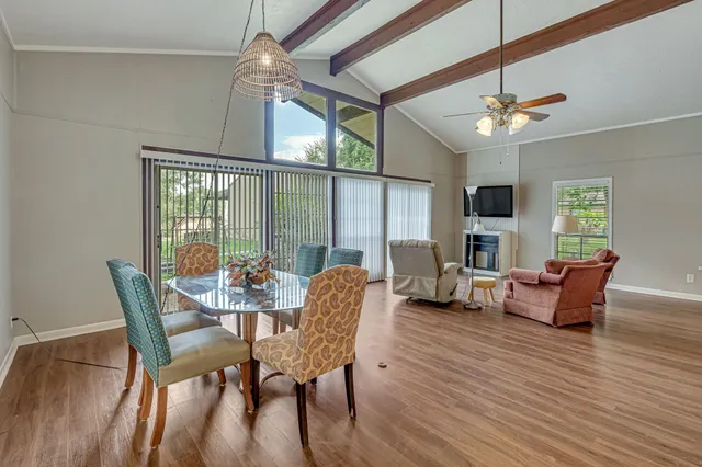 a dining room with furniture a chandelier and wooden floor