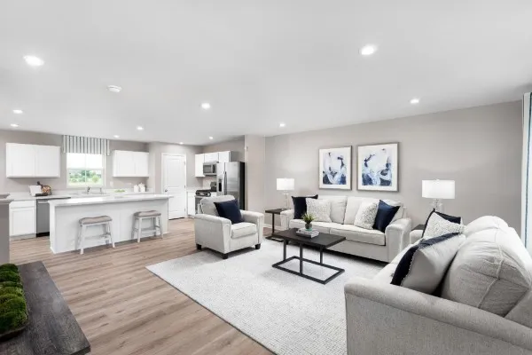 a living room with furniture white walls and kitchen view