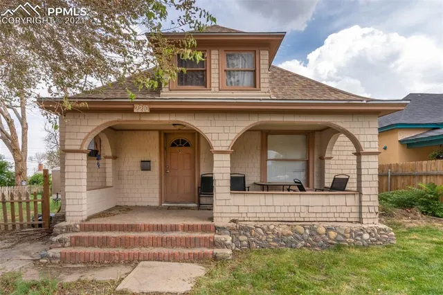 a view of a grey house with large windows