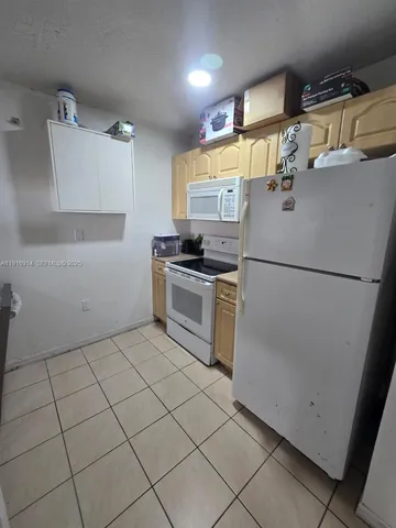 a kitchen with granite countertop a sink and a refrigerator