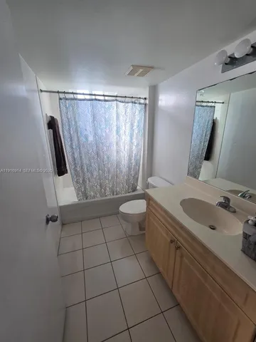a bathroom with a sink a toilet a mirror and shower