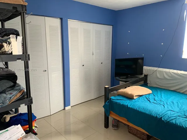 a bedroom with furniture and a flat screen tv