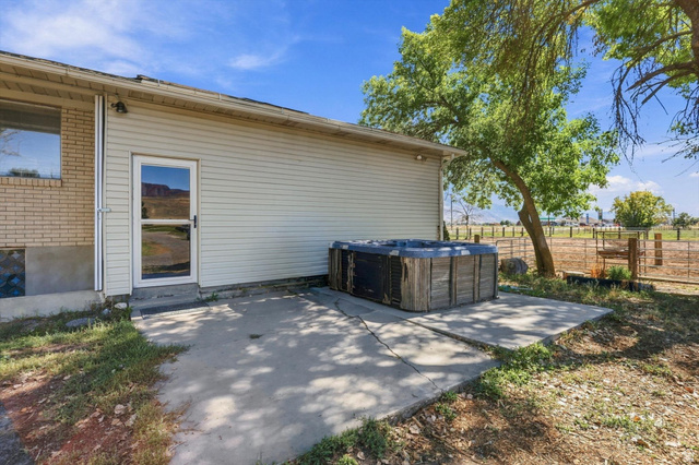 15295 North 5400th Street West Riverside, UT 84334 - Photo 40 of 54 Patio area featuring a hot tub, brick and siding exterior, and a glass-paneled exterior door