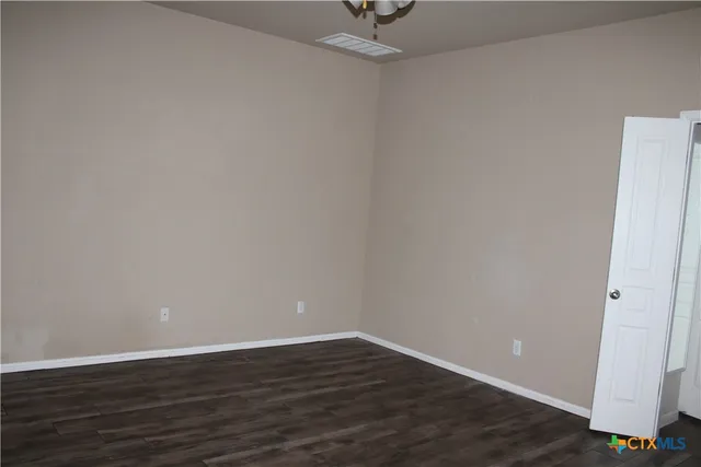 a view of an empty room with wooden floor