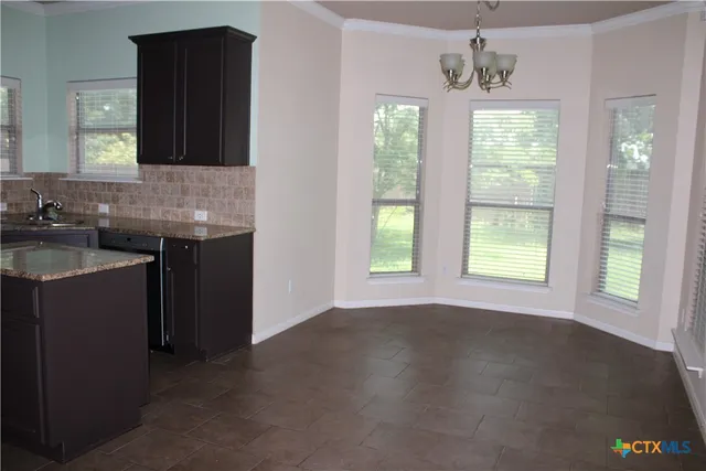 a kitchen with stainless steel appliances granite countertop a sink dishwasher a stove and a refrigerator with wooden floor