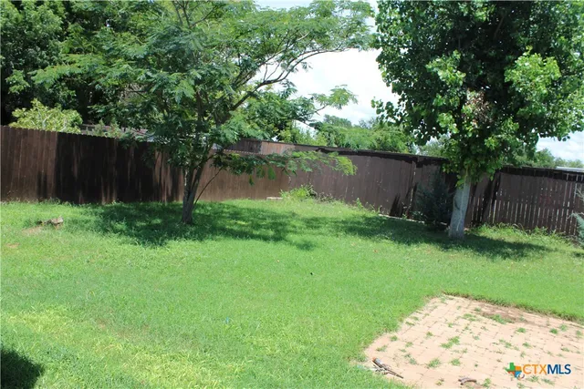 a backyard of a house with lots of green space and lake view