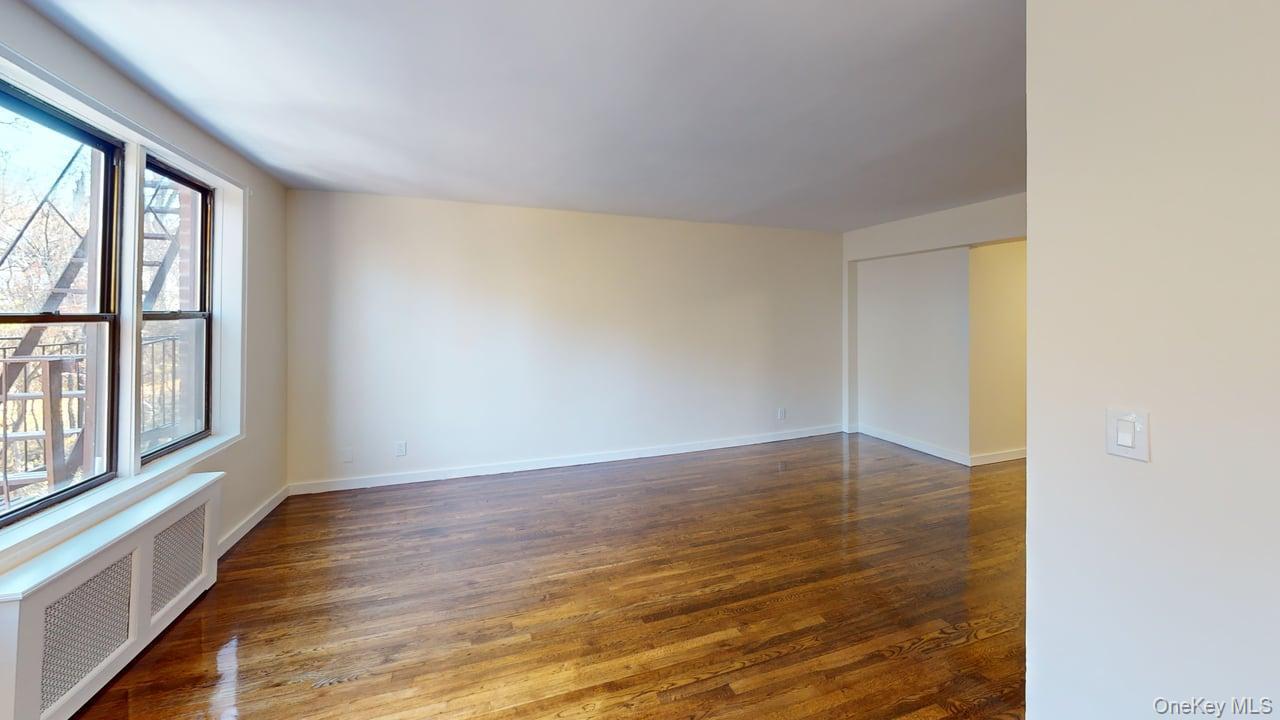 678 Warburton Avenue, Unit 6L Yonkers, NY 10701 - Photo 10 of 14 a view of an empty room with wooden floor and a window