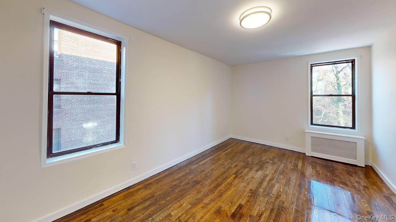 678 Warburton Avenue, Unit 6L Yonkers, NY 10701 - Photo 11 of 14 an empty room with wooden floor and windows