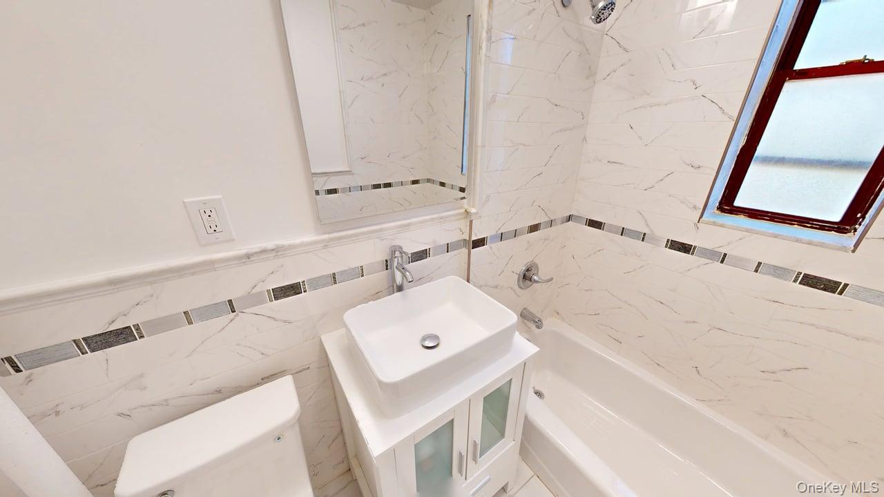 678 Warburton Avenue, Unit 6L Yonkers, NY 10701 - Photo 5 of 14 a bathroom with a bathtub sink and mirror
