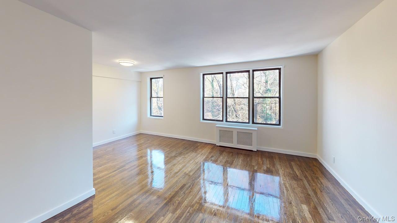 678 Warburton Avenue, Unit 6L Yonkers, NY 10701 - Photo 6 of 14 an empty room with wooden floor and windows