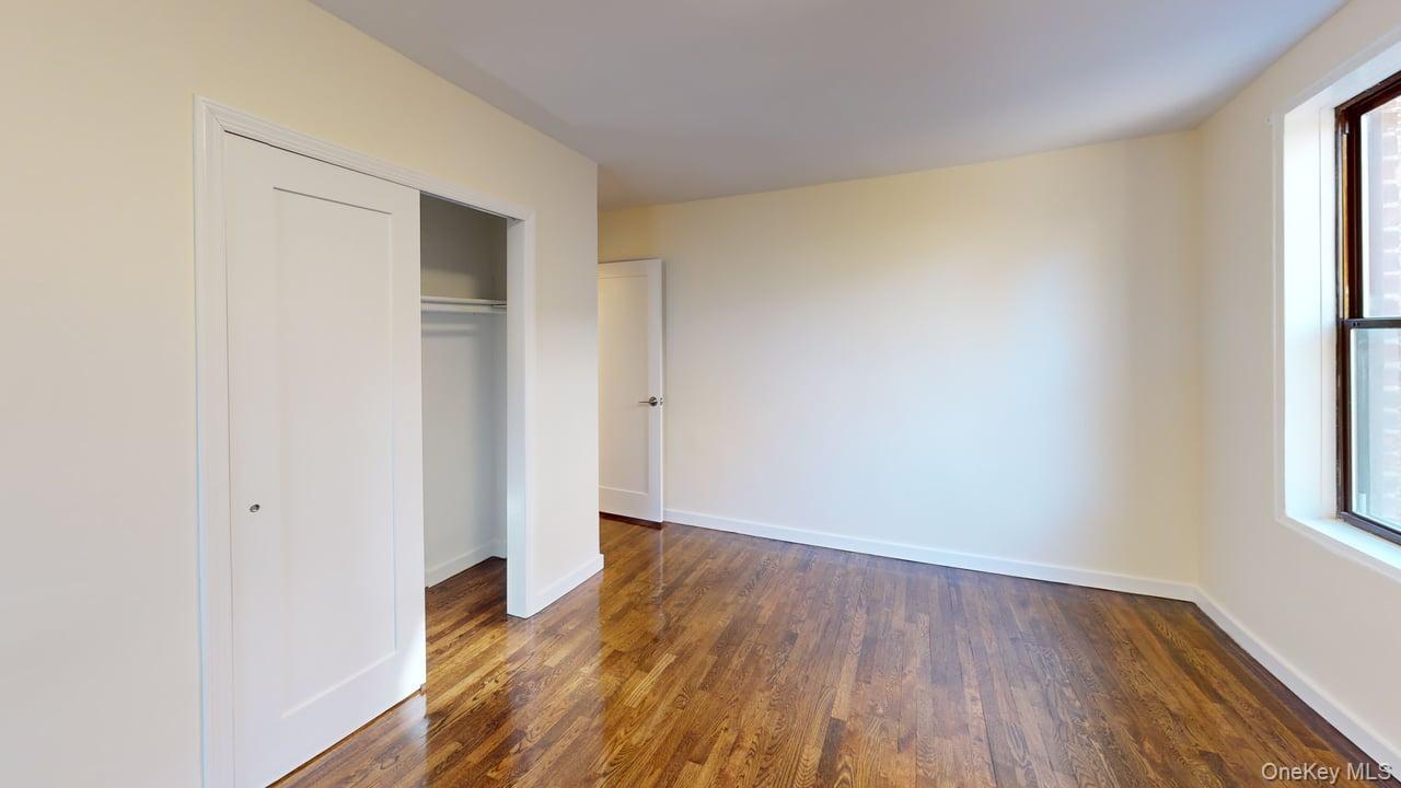 678 Warburton Avenue, Unit 6L Yonkers, NY 10701 - Photo 8 of 14 an empty room with wooden floor and windows