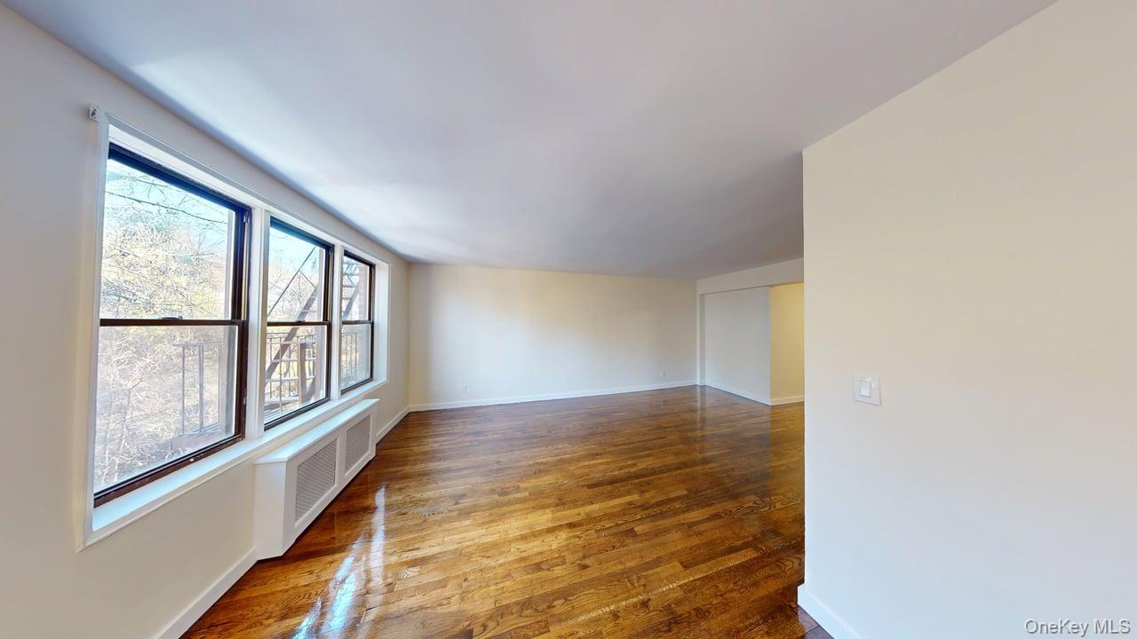 678 Warburton Avenue, Unit 6L Yonkers, NY 10701 - Photo 9 of 14 a view of an empty room with wooden floor and a window
