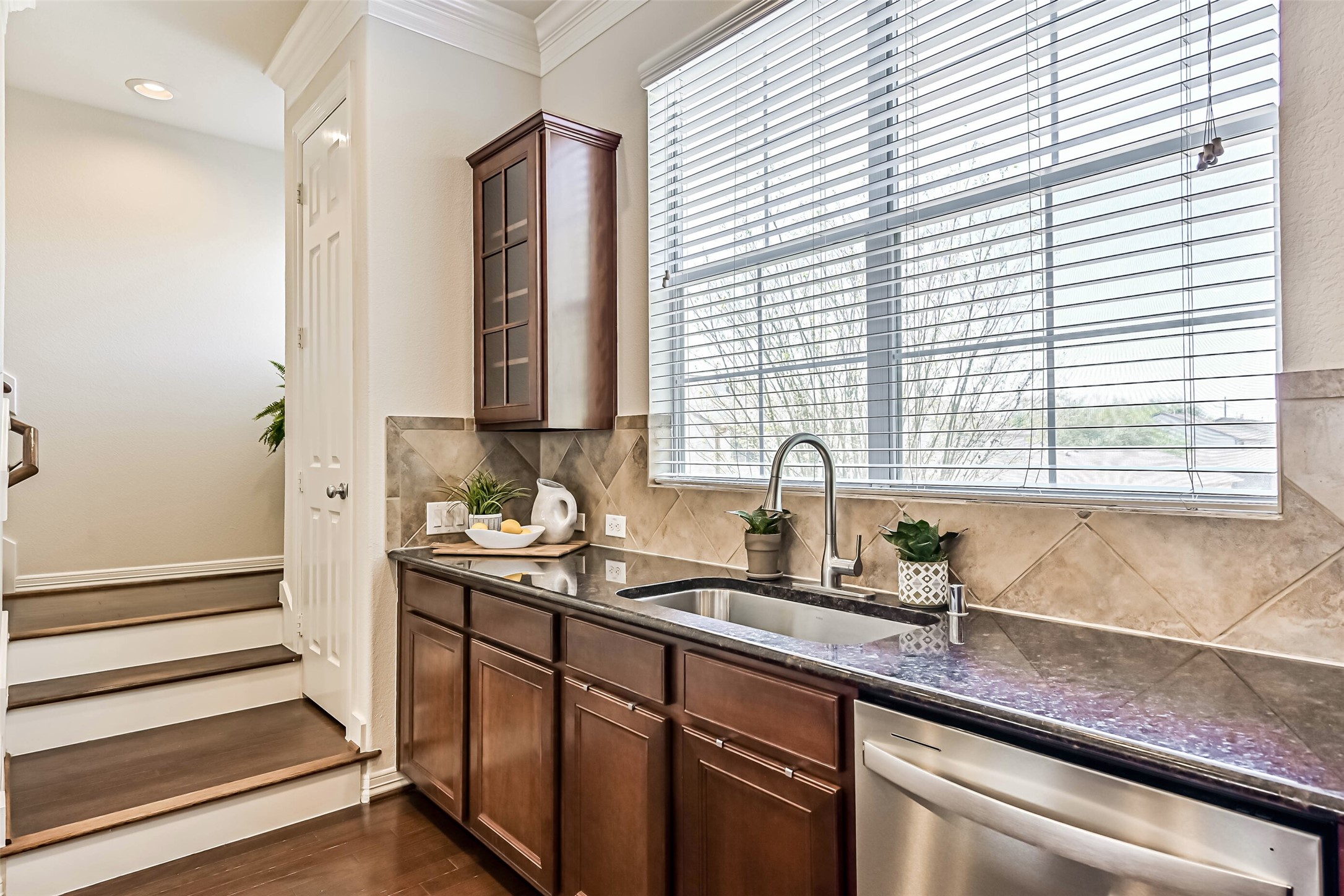 3208 Clearview Circle Houston, TX 77025 - Photo 14 of 30 Glass-front upper cabinets and a tiled backsplash add character to the spac