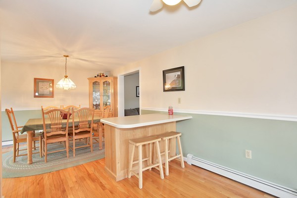 11 Robbins Road Ayer, MA 01432 - Photo 9 of 30 a view of a kitchen with a dining table chairs and a wooden floor