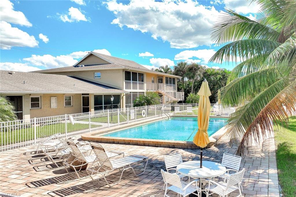 2000 Alamanda Drive, Unit 104 Naples, FL 34102 - Photo 14 of 32 a view of a house with a backyard and a patio