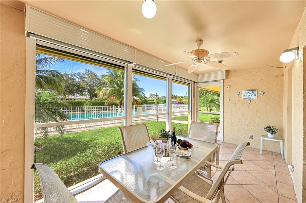 2000 Alamanda Drive, Unit 104 Naples, FL 34102 - Photo 17 of 32 a view of a dining room with furniture wooden floor and a chandelier