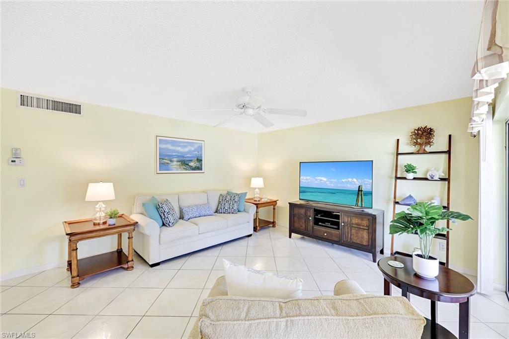 2000 Alamanda Drive, Unit 104 Naples, FL 34102 - Photo 18 of 32 a living room with furniture a flat screen tv and a potted plant