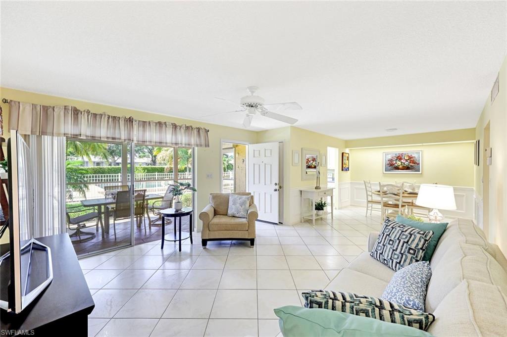 2000 Alamanda Drive, Unit 104 Naples, FL 34102 - Photo 20 of 32 a living room with furniture and a floor to ceiling window
