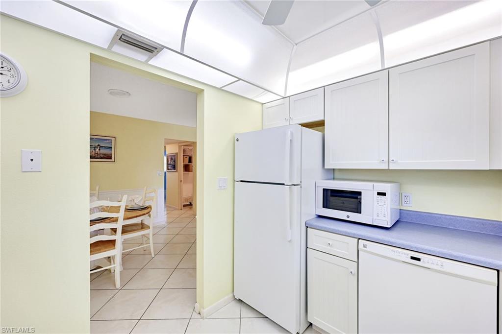 2000 Alamanda Drive, Unit 104 Naples, FL 34102 - Photo 25 of 32 a kitchen with cabinets a refrigerator and a sink