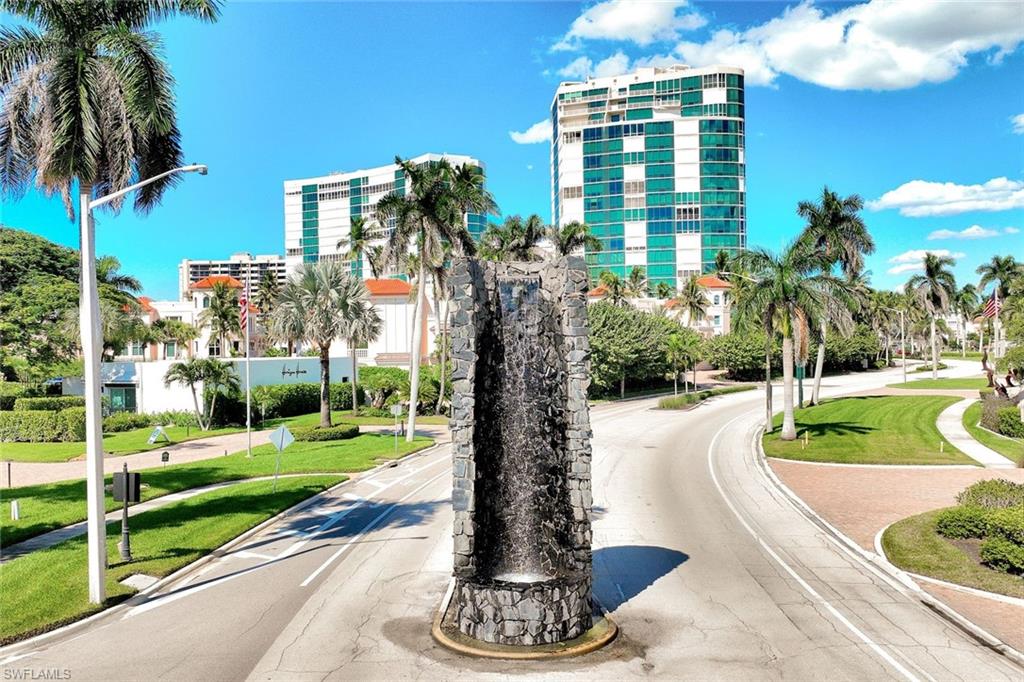 2000 Alamanda Drive, Unit 104 Naples, FL 34102 - Photo 9 of 32 a front view of a building with a yard and trees