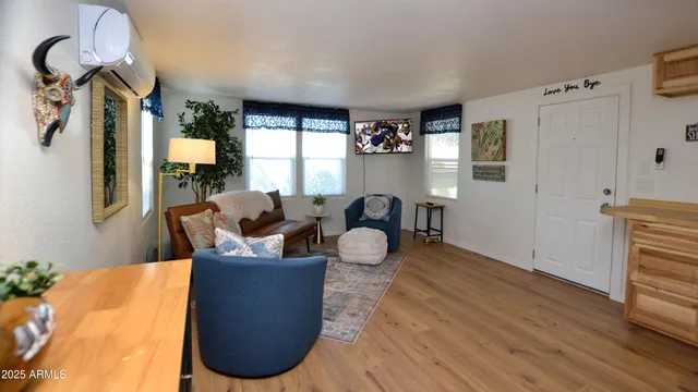 a living room with furniture a flat screen tv and a window
