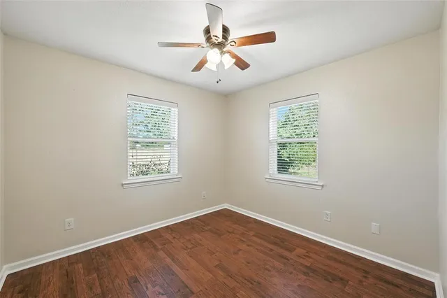 a view of a room with wooden floor and a ceiling fan